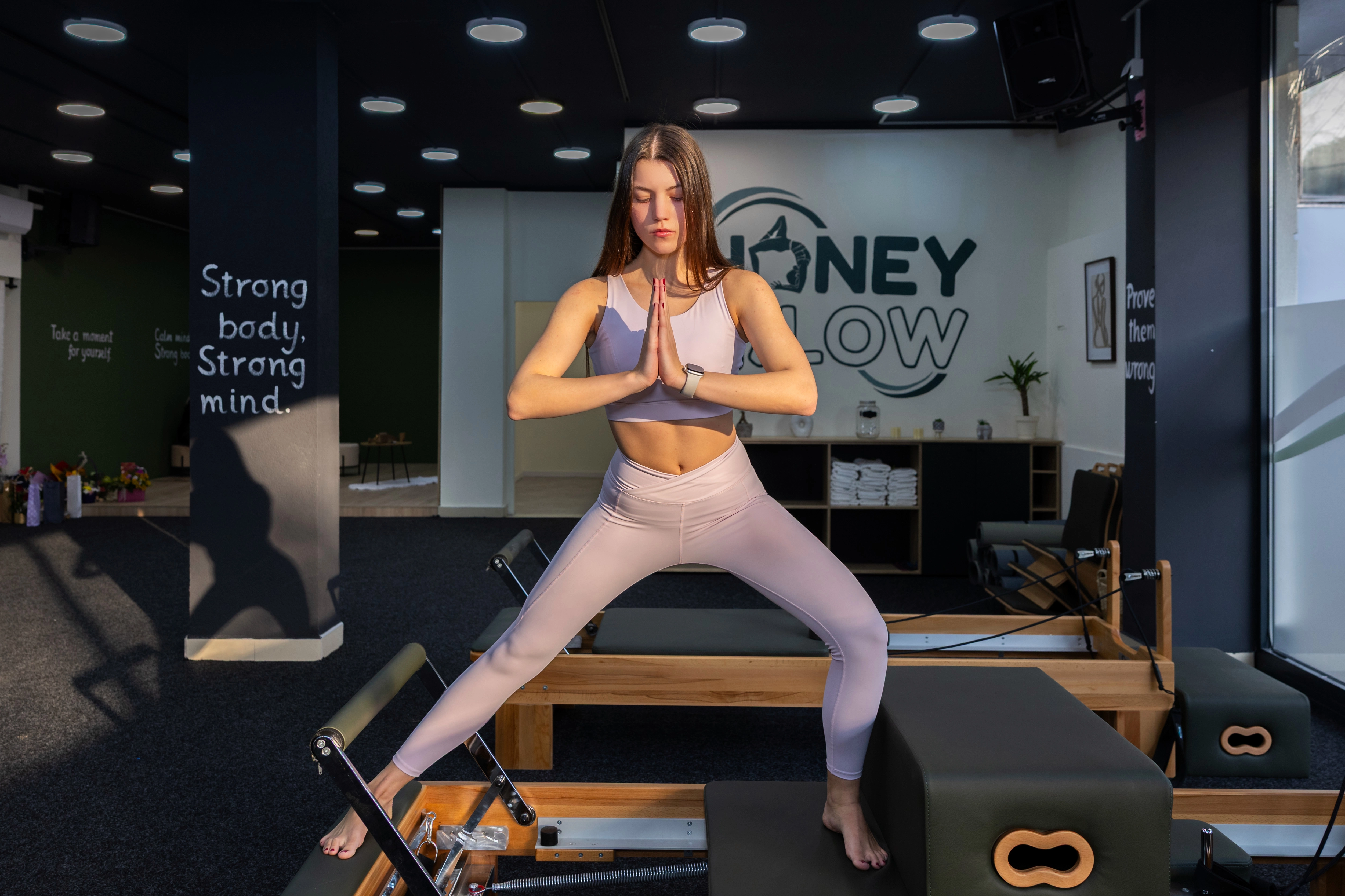 Pilates instruktorka pokazuje pravilno izvođenje vežbi na reformeru